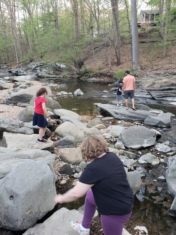 people walking on rocks in a creek